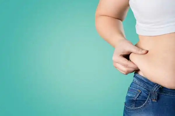 Image of woman pinching her love handles to show weight gain Southend